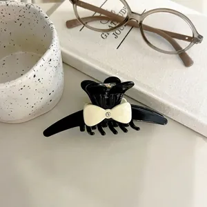 Elegant black and cream acetate bow hair claw clip with a centered small diamond detail