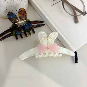 Close-up of acetic acid butterfly hair clips with elegant pink bow and rhinestone details