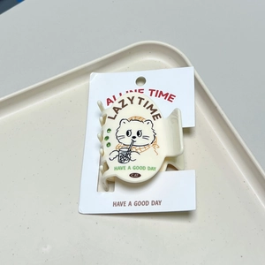 Detail view of cream resin cat hair clip with green rhinestones and lazy time text design
