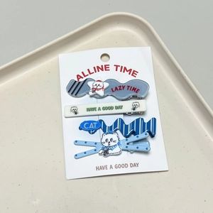 Detail view of four blue and white cat themed hair clips on a white display card