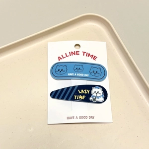 Close-up of cat-themed hair clips with blue cartoon illustrations and lazy time text