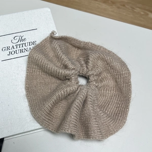 Chouchou élégant en maille de vison marron café sur une surface blanche minimaliste