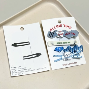 Detailed view of cat and heart pattern hair clips set on a beige display tray