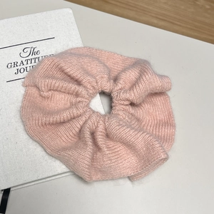 Gros plan détaillé d'un chouchou surdimensionné en tricot rose avec plis texturés