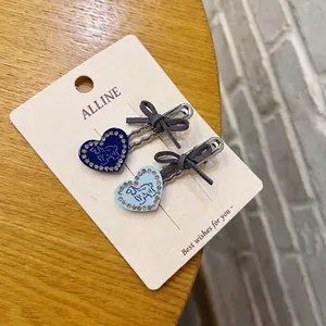 Dettaglio di fermagli per capelli blu a cuore con stampe di cani e fiocchi di velluto