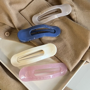 Set of four minimalist oval hair claws in grey blue white and pink on knitwear