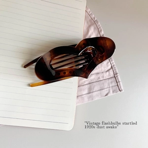 Detail of dark brown tortoiseshell hair claw clip with vintage hollowed butterfly design