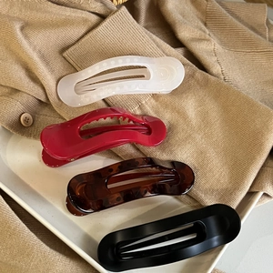 Set of four elegant hair claws in tortoise shell, matte black, and red resin finishes