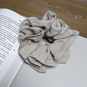 Chouchou élégant à rayures beige et marron posé sur un livre ouvert pour femmes