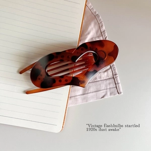 Detailed view of a vintage tortoiseshell hair claw clip with classic amber patterns
