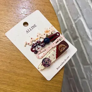 Dettaglio di 4 mollette dolci con motivi di cani, tessuto floreale e perline su una carta