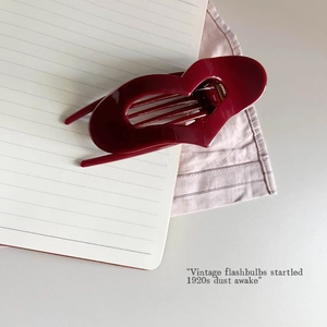 Detail view of the burgundy heart-shaped hair claw clip with glossy finish and secure teeth