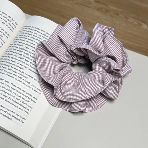 Chouchou élégant en tissu à rayures violettes avec texture sur fond de livre vintage
