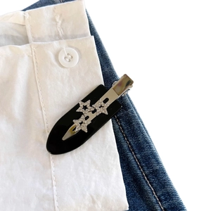 Fermaglio per capelli a stella con strass su camicia bianca e bordo di jeans blu