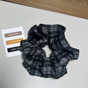 Klassisches schwarz-weiß kariertes Haargummi mit Stofflagen im Retro-College-Stil