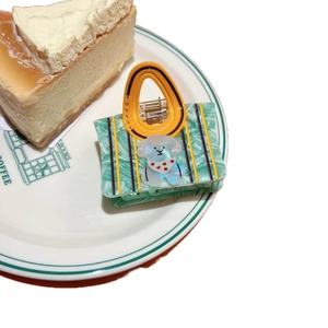 Pinza para el pelo de acetato verde jaspeado con forma de bolso y detalle de perro blanco