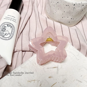 Détail de la pince à cheveux rose en forme d'étoile avec résine transparente et ressort métal