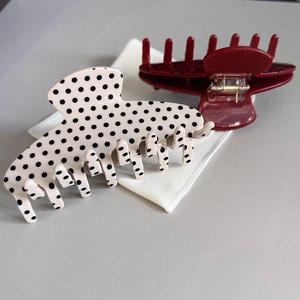 Close-up of retro acetate polka dot hair claws in cream and red colors with smooth finish