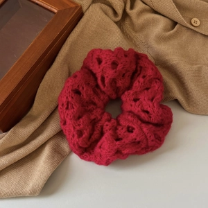 Red knit scrunchie with hollow crochet design for hair styling in autumn and winter