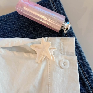 Primer plano detallado de una pinza para el pelo de estrella de mar blanca perlada
