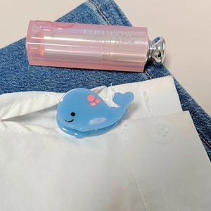Primer plano de una linda mini pinza para el cabello de ballena azul en denim