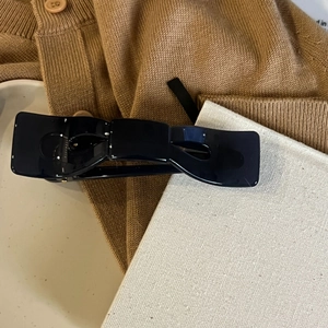 Nahaufnahme einer glänzend tiefblauen Schleifen-Haarklammer auf neutralem Textilstoff