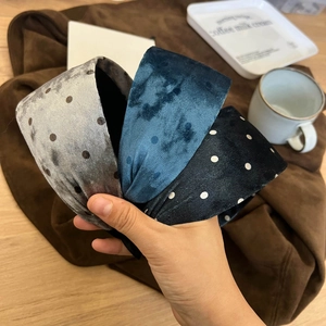 Detailed texture of velvet knot headbands in grey, blue, and black with polka dots pattern