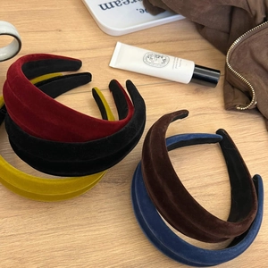 Velvet padded headbands in multiple colors on wooden desk for elegant hair styling