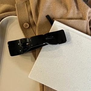 Detail einer eleganten schwarzen Schleifen-Haarklammer auf einem Tablett für den French Style