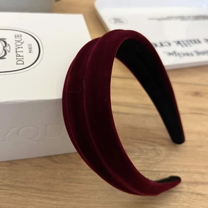 Detail view of burgundy velvet headband featuring thick padded design and soft velvet texture