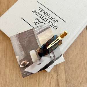 Detailed view of tortoiseshell acetate hair clip featuring gold Creation France logo text