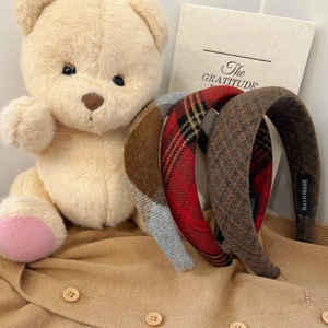 Detailed close-up of thick plaid wool headbands with handmade label for women
