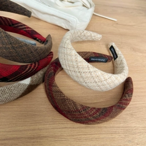 Handmade autumn winter plaid woolen headbands in various colors on wooden surface