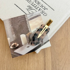 Detailed view of tortoiseshell acetate hair clip with gold metal grip and French engraving