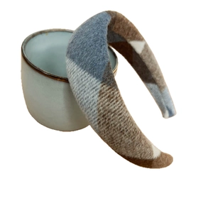 Blue and brown plaid wool headband for women displayed on a grey ceramic support