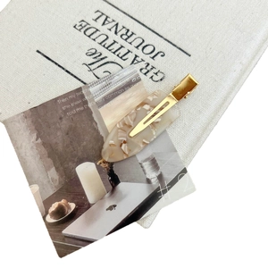 French acetate hair clip with gold metal finish and beige marble pattern