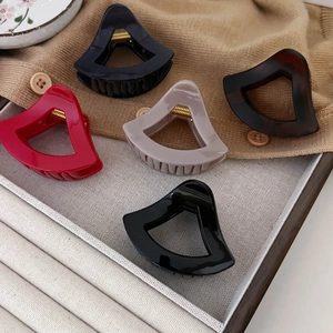 Französischer hohler Dreieck-Haarclip in fünf eleganten Farben auf einem Tablett