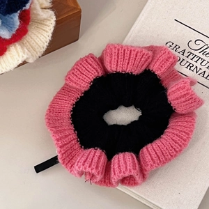Détails du chouchou en maille rose et noir à côté d'un journal de gratitude