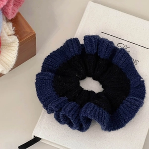 Gros plan sur chouchou en maille avec texture de laine contrastée bleu nuit et noir