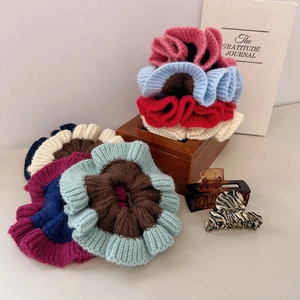 Détail de chouchous en tricot et pinces à cheveux aux couleurs rétro sur boîte bois