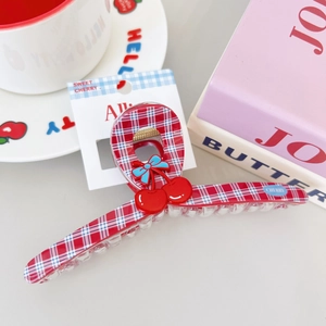 Plaid hair claw clip with red cherry and blue bow decoration for a preppy style look