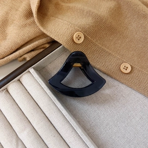 Detail der eleganten dunkelblauen hohl geschnittenen Haarklammer auf beigem Samttablett