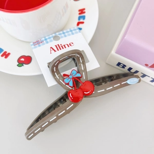 Detail view of brown cherry hair claw clip with blue bow on a sweet lifestyle display