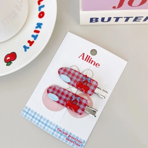 Detail of cherry-patterned bow hair clips with red resin cherries in a two-piece set