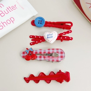 Detail of 4-piece red cherry and plaid hair clips set with sweet heart decorations