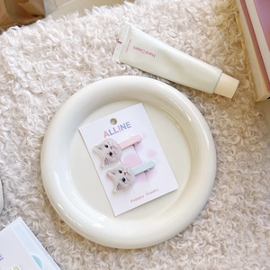 Dettaglio di simpatiche mollette per capelli a forma di gatto in rosa e blu