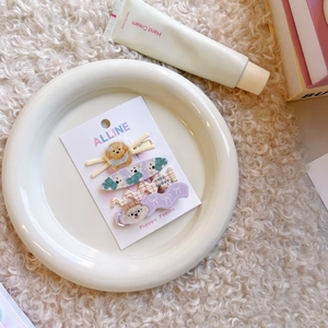Dettaglio del set di 4 fermagli per capelli con cuccioli fiocco e motivi a quadri