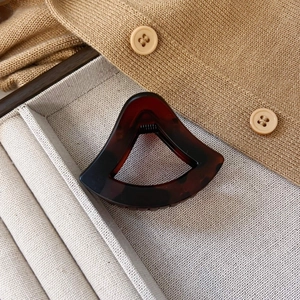 Detail einer hohlen Haarklammer mit Schildpatt-Muster auf Leinen und Strickwaren