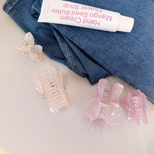 Detailansicht von vier perlmuttfarbenen Schmetterlings-Haarklammern in Rosa und Creme