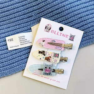 Detailed close-up of a three-piece hair clip set with cute cat and dog patterns